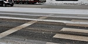 crosswalk on road in winter with snow and ice