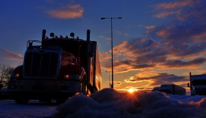 18-wheelers pulled over in the snow at sunset